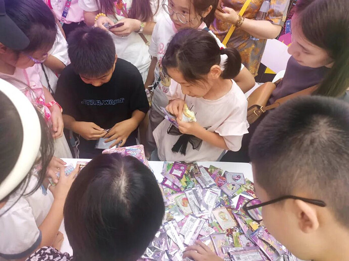 图为一群人在围观“端盒”(指整盒购买卡包并开包)